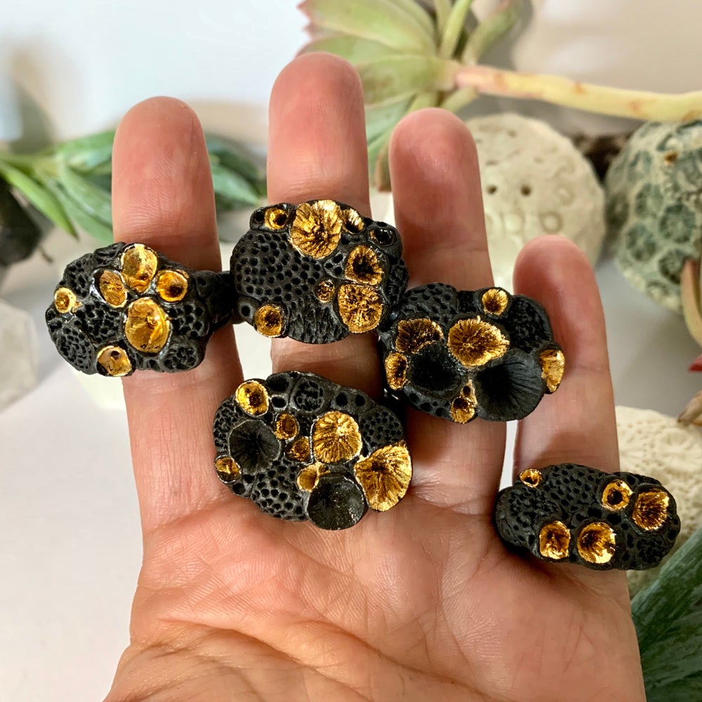 One black and gold ‘rock coral’ porcelain ring